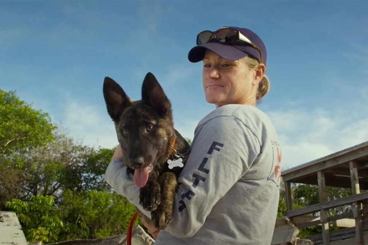 A woman holding a German Shepherd