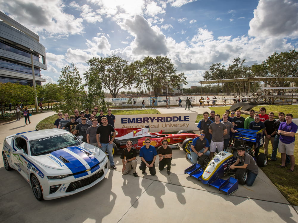 Eco Car and Eco Race car are surrounded by students.