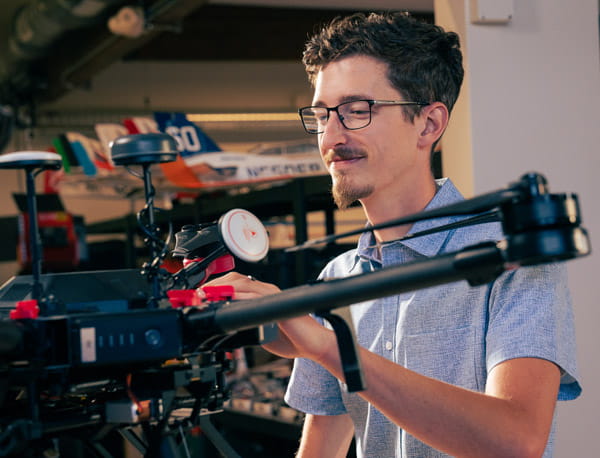 A person working on a drone in a laboratory setting.