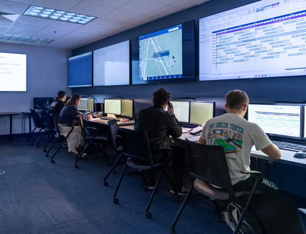 Four people working in an airline control room.