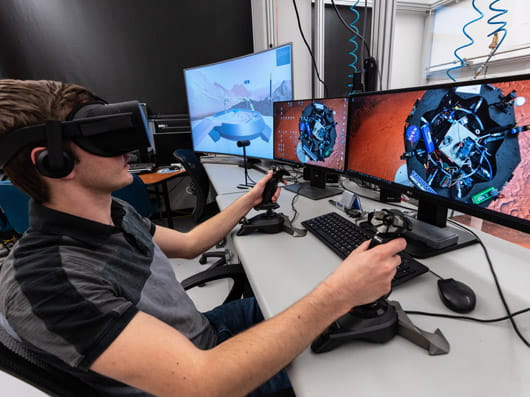 person wearing virtual reality goggles while interacting with a simulated environment.