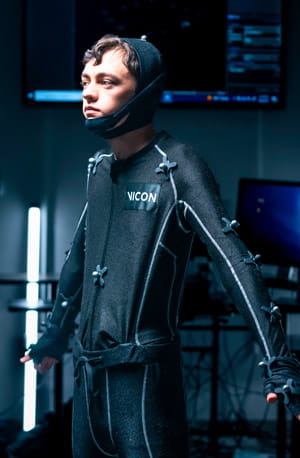 A person wearing a motion capture suit with sensors.