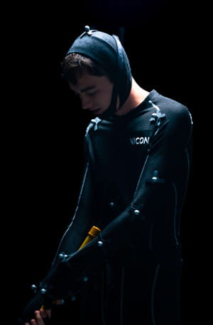 A person wearing a motion capture suit with sensors and hood.