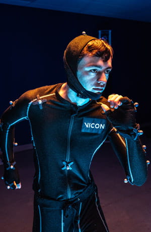 A person wearing a motion capture suit with sensors.