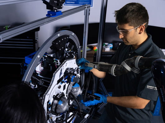 A person wearing safety glasses while working on some equipment.