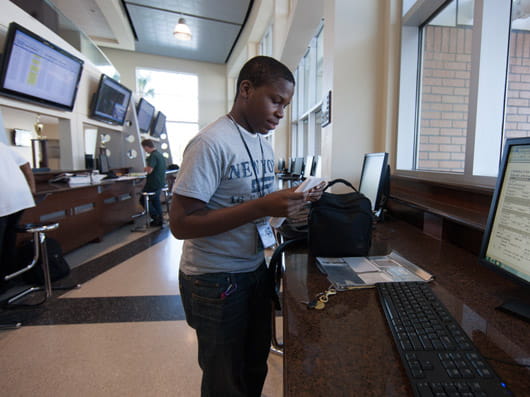 A person standing at a workstation in the flight operations center.