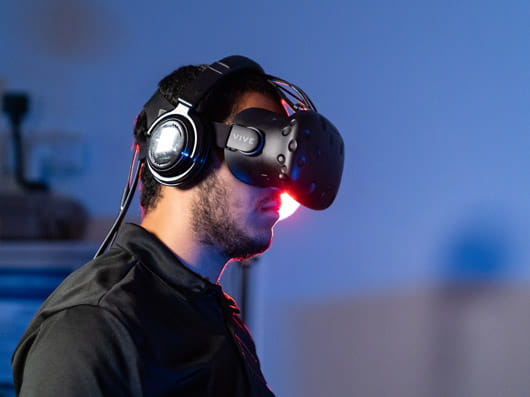 A person wearing virtual reality goggles and headphones.
