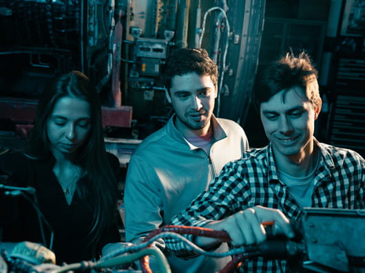 Three students working together on lab equipment.