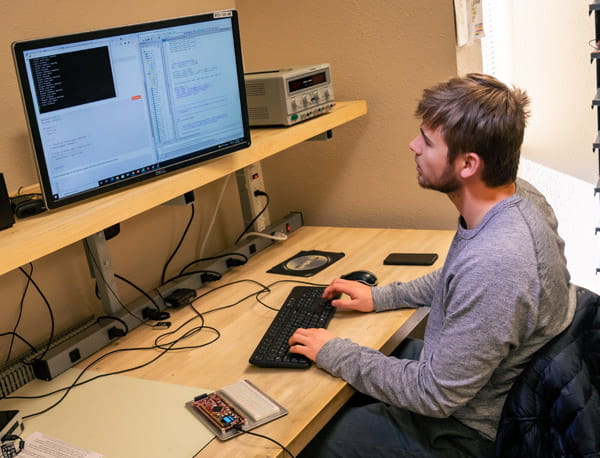 A person sitting at a desk, working on a computer.
