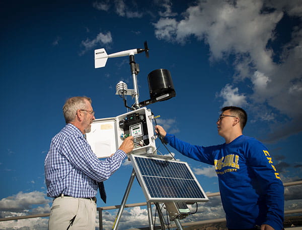Meterology student and professor study weather factors