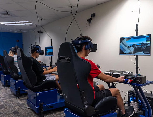 Students sitting and operating flight simulators in the Preflight Immersion Lab.