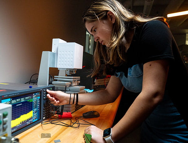 An Embry-Riddle student pushes buttons on a device in the Radar and Microwaves Lab.