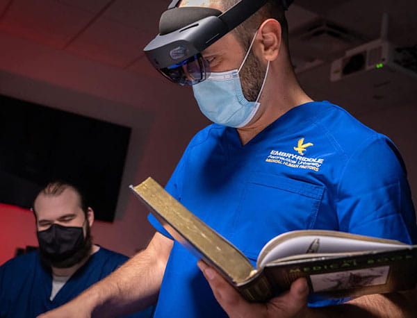 An Embry-Riddle professor holds a textbook.