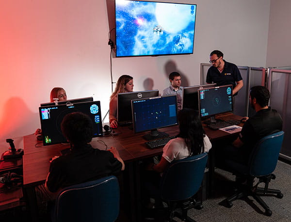 A professor instructs students in a computer lab.