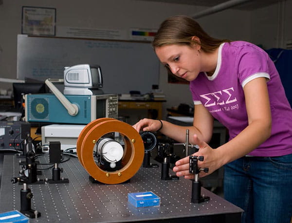 A female Embry-Riddle student works with equipment at a desk.