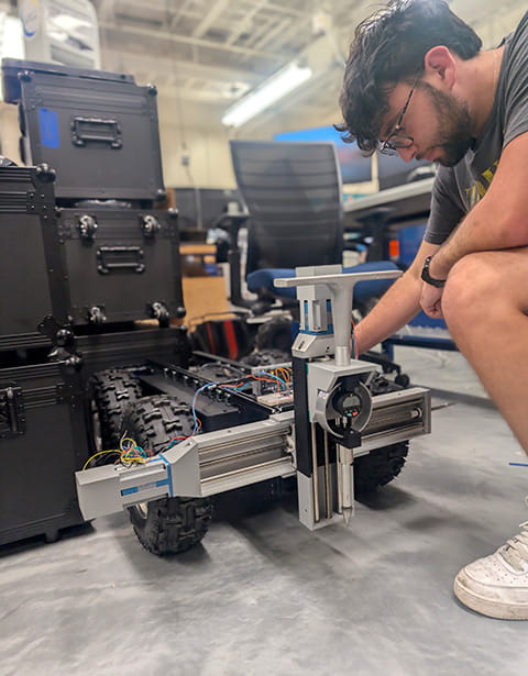 A student works with a robot in the SRGE Lab
