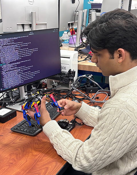 A student works with a robot in the SRGE Lab