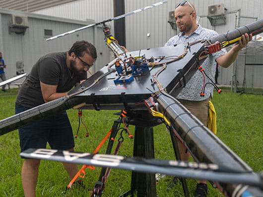 Two students work on a giant drone