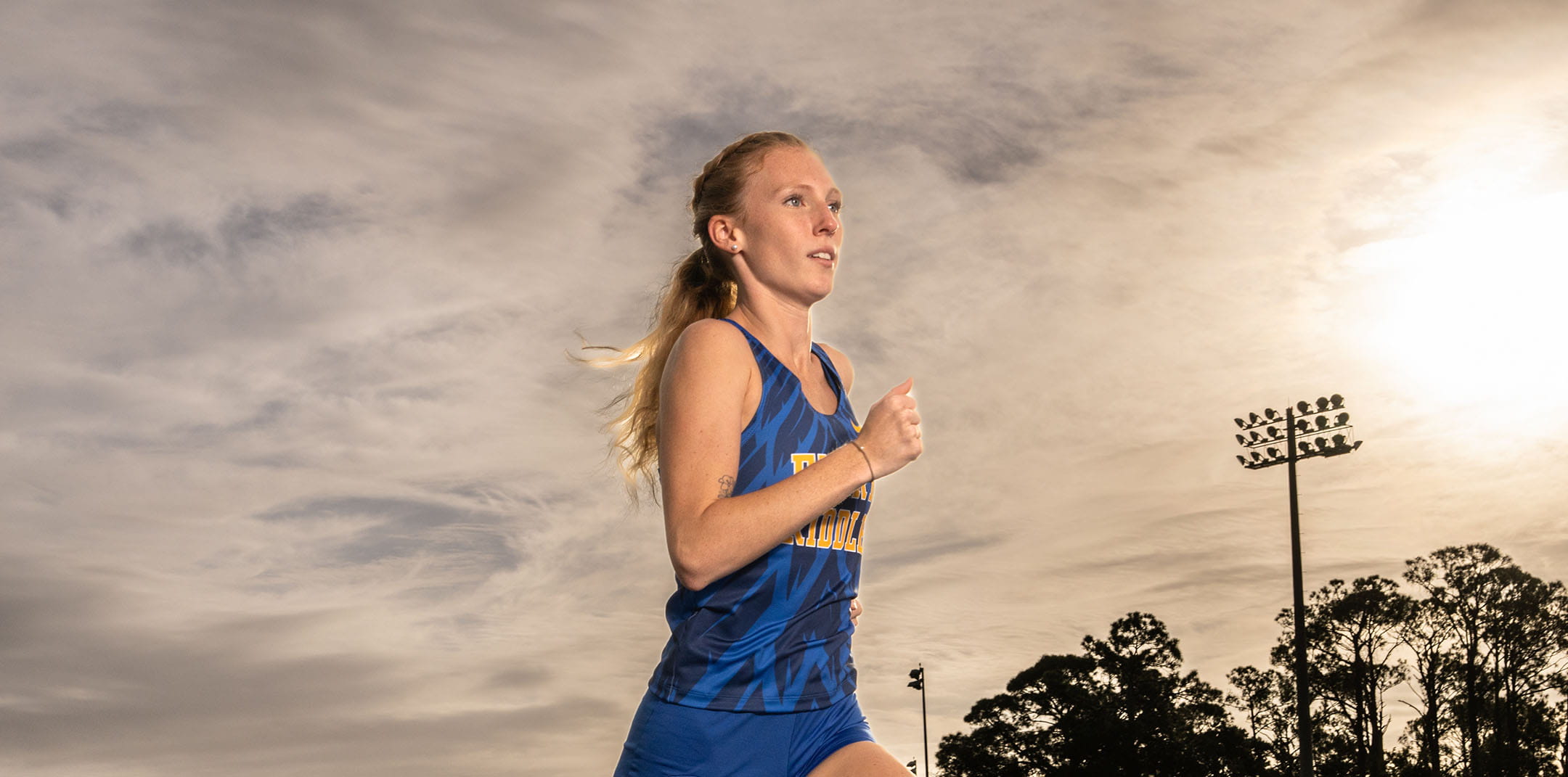 Embry-Riddle student, Abigail Valley, runs on a track at sunset