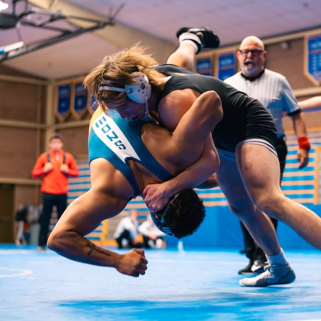 An Embry-Riddle wrestling match where a student pins another as a referee looks on