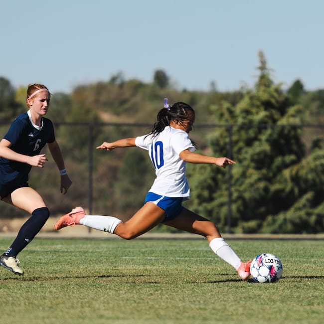 Embry-Riddle soccer player kicks a ball before a member of the opposing team can steal it