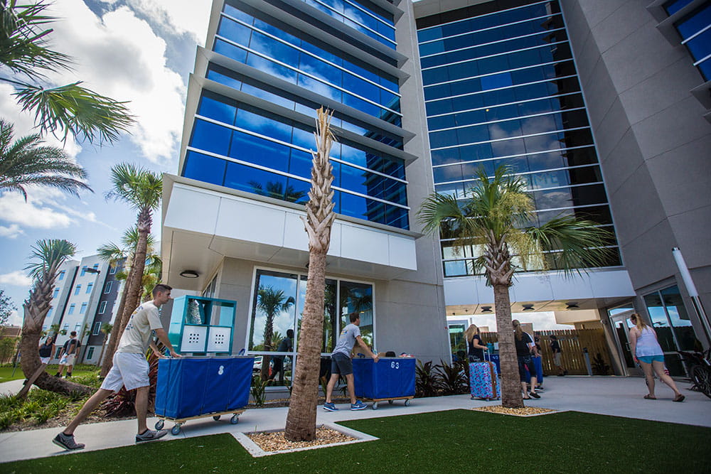 Students move in to the Embry-Riddle Daytona Beach campus, pushing blue carts