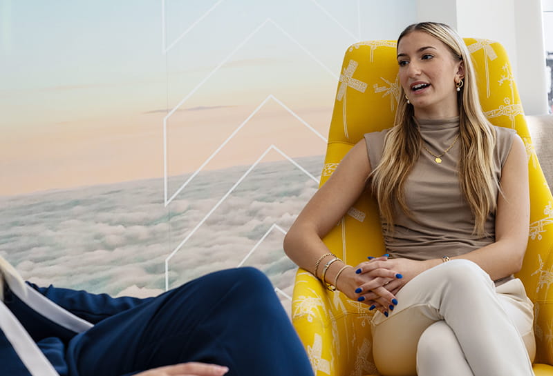 An Embry-Riddle student sits on a chair talking to a mentor