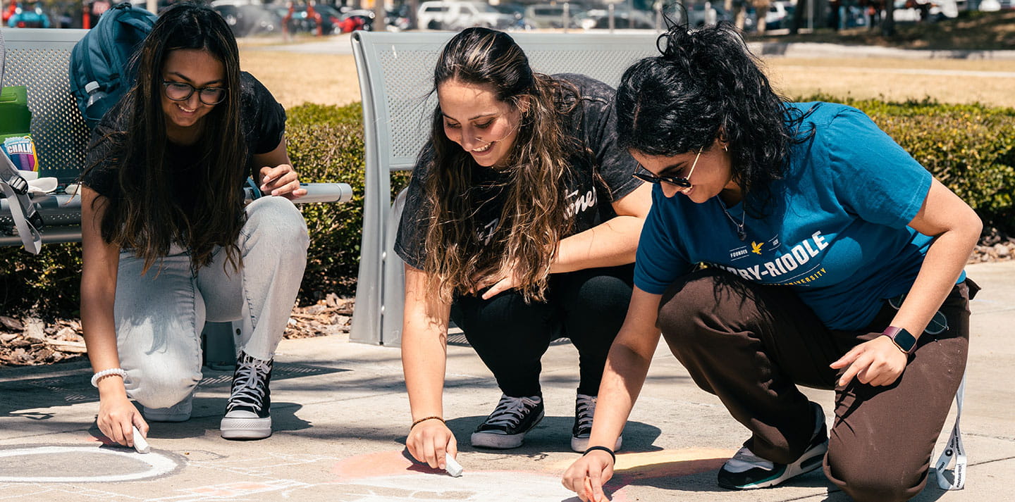Embry-Riddle students doing chalk art on the sidewalk