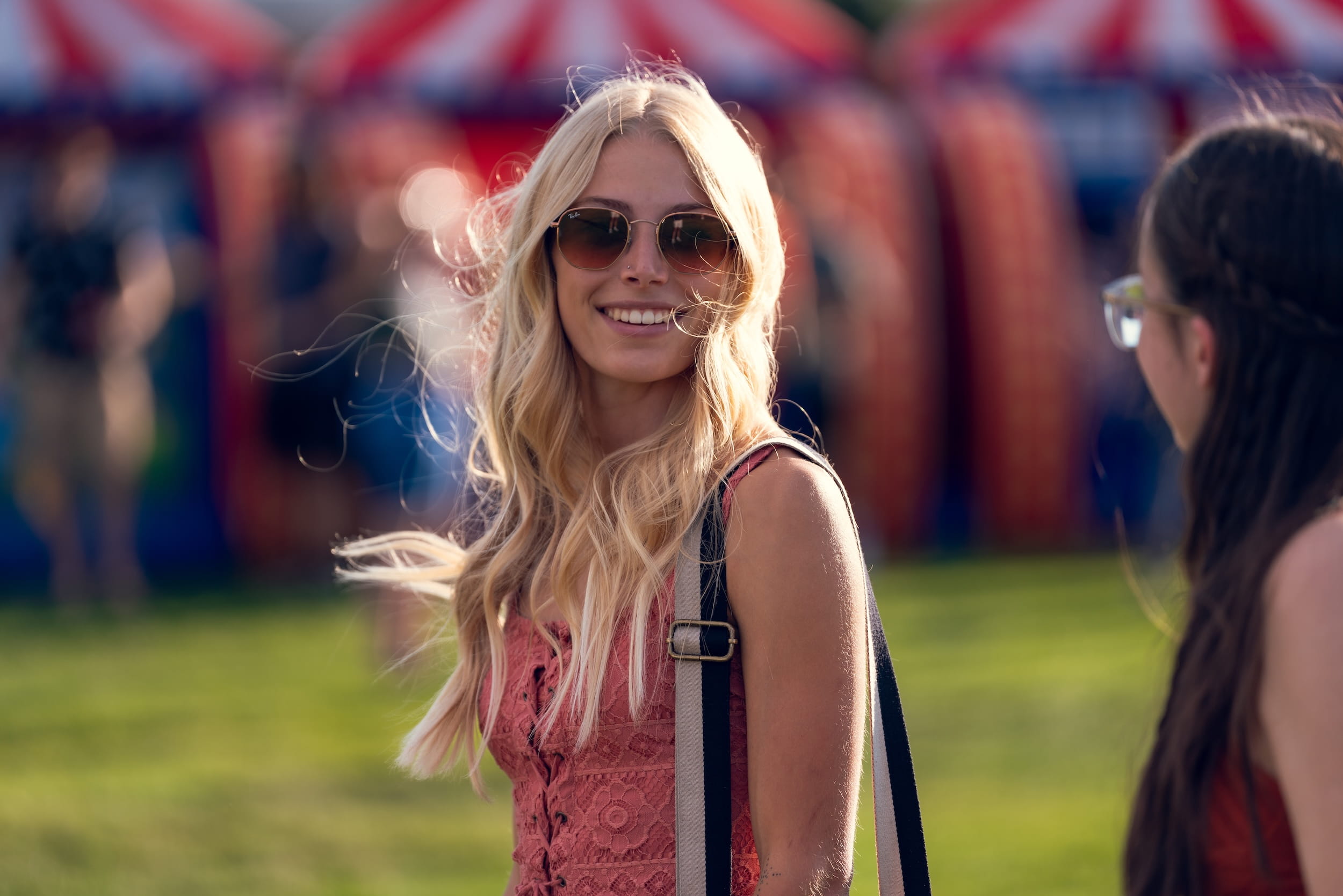 A female student in sunglasses walks alongside another student