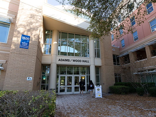 Exterior of Adams and Wood Halls with students walking in