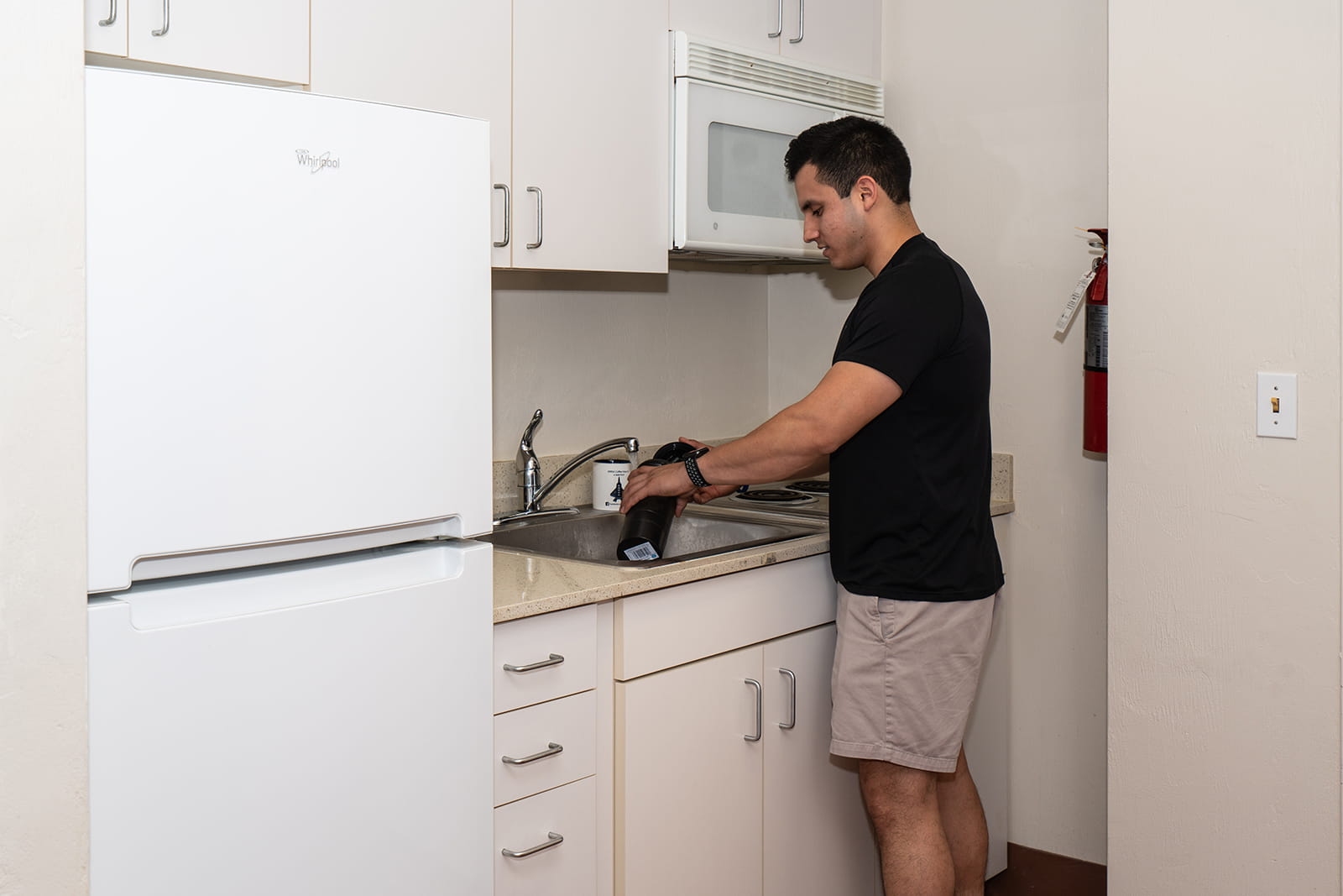 A student washes dishes in Stimpson Hall