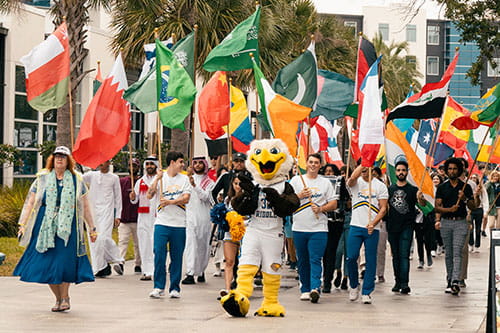 Students walk with flags of different countries during International Week