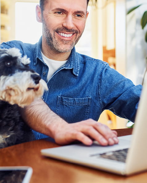 Student with laptop and a dog sitting nearby