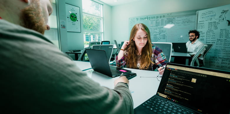 A group of students studying together in a small room.