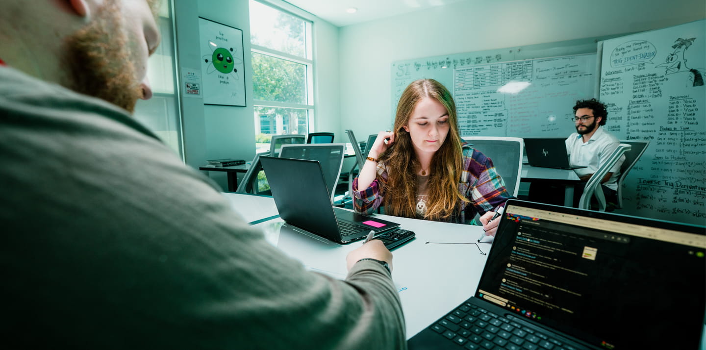 A group of students studying together in a small room.