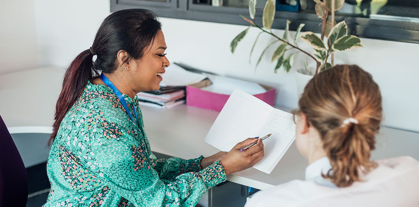 A female teacher having a discussion with a male student