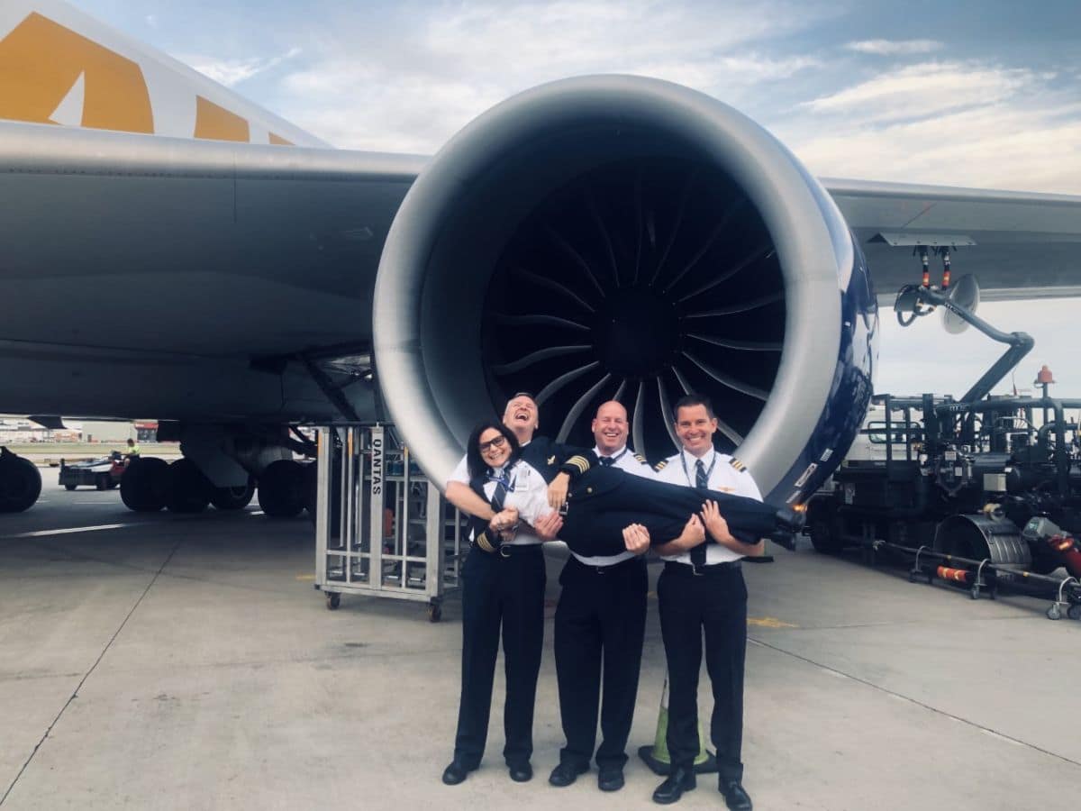 Gina Buhl ('89) being held up by her fellow pilots in front of a 747. (Photo: Gina Buhl)