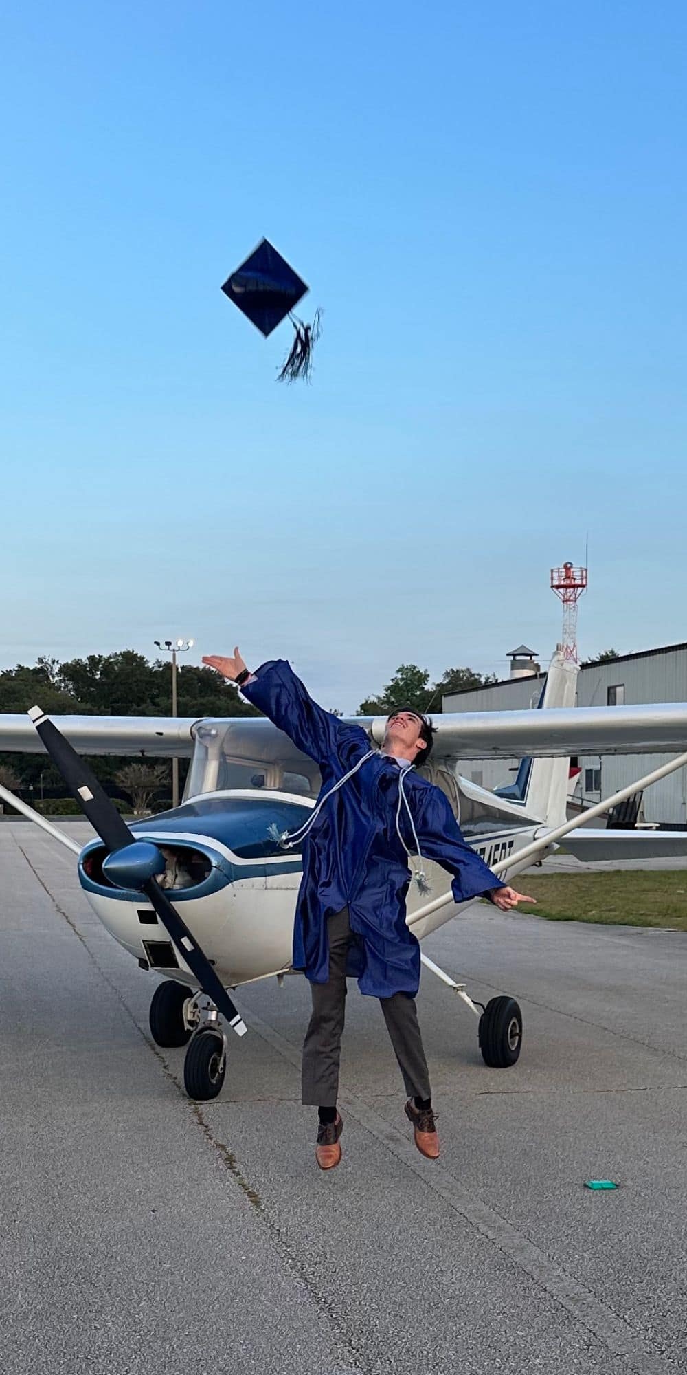 Dual Enrollment student Noah Burrows tosses his graduate cap into the air in front of his family’s Cessna 172. (Photo: Noah Burrows)