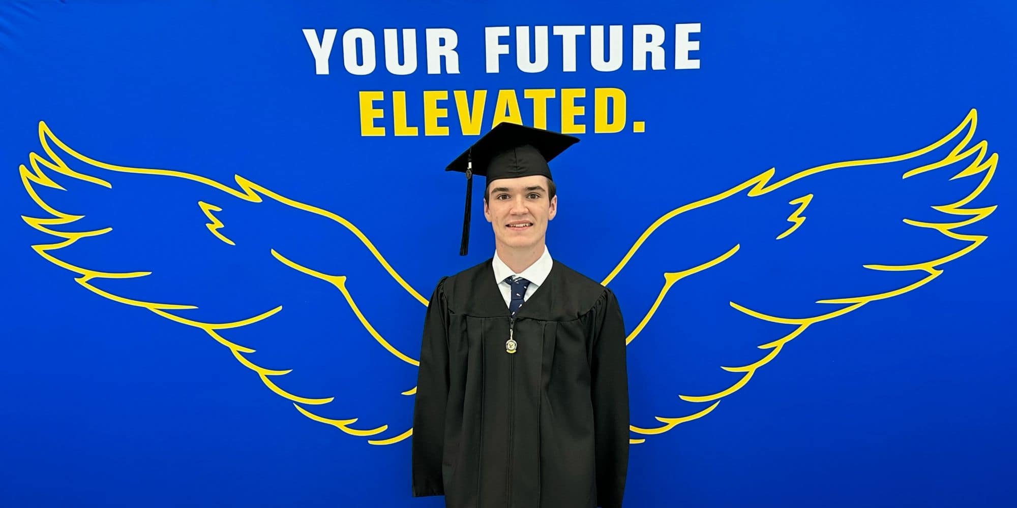 Dual Enrollment student Noah Burrows in front of Embry-Riddle’s “Your Future. Elevated” sign. (Photo: Noah Burrows)