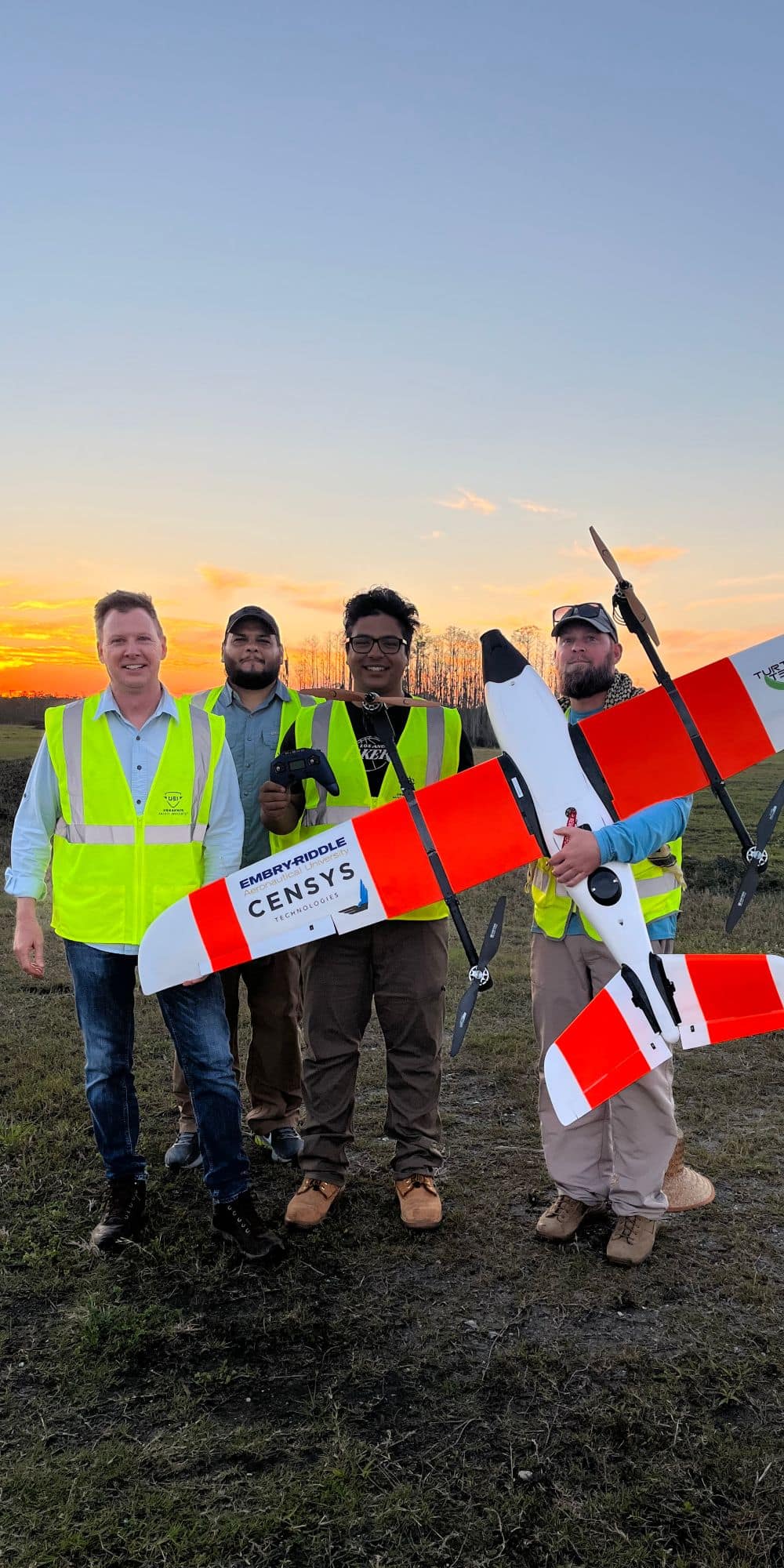 UAS student Jose Cabrera ('22, '24) standing beside his peers and colleagues holding an uncrewed aircraft system used to observe endangered sea turtle behavior. (Photo: Jose Cabrera)