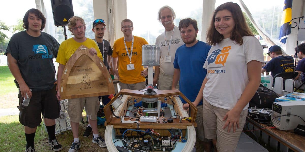 The Embry-Riddle RAER team stands with their "Double Precision" autonomous watercraft for the AUVSI Foundation's International Roboboat Competition.