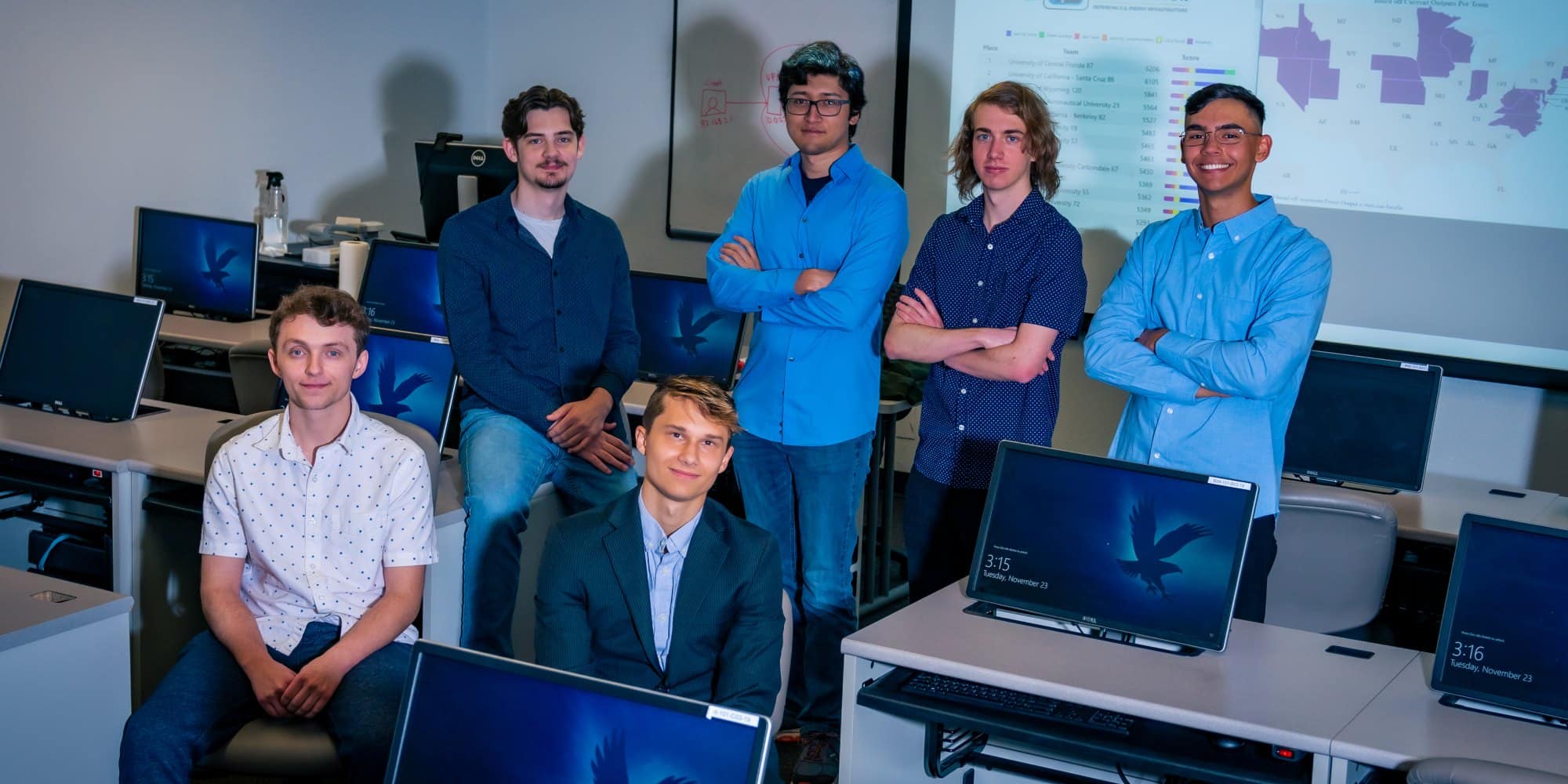 The students of the CyberForce team standing in a Cyber Intelligence laboratory on the Prescott campus. 