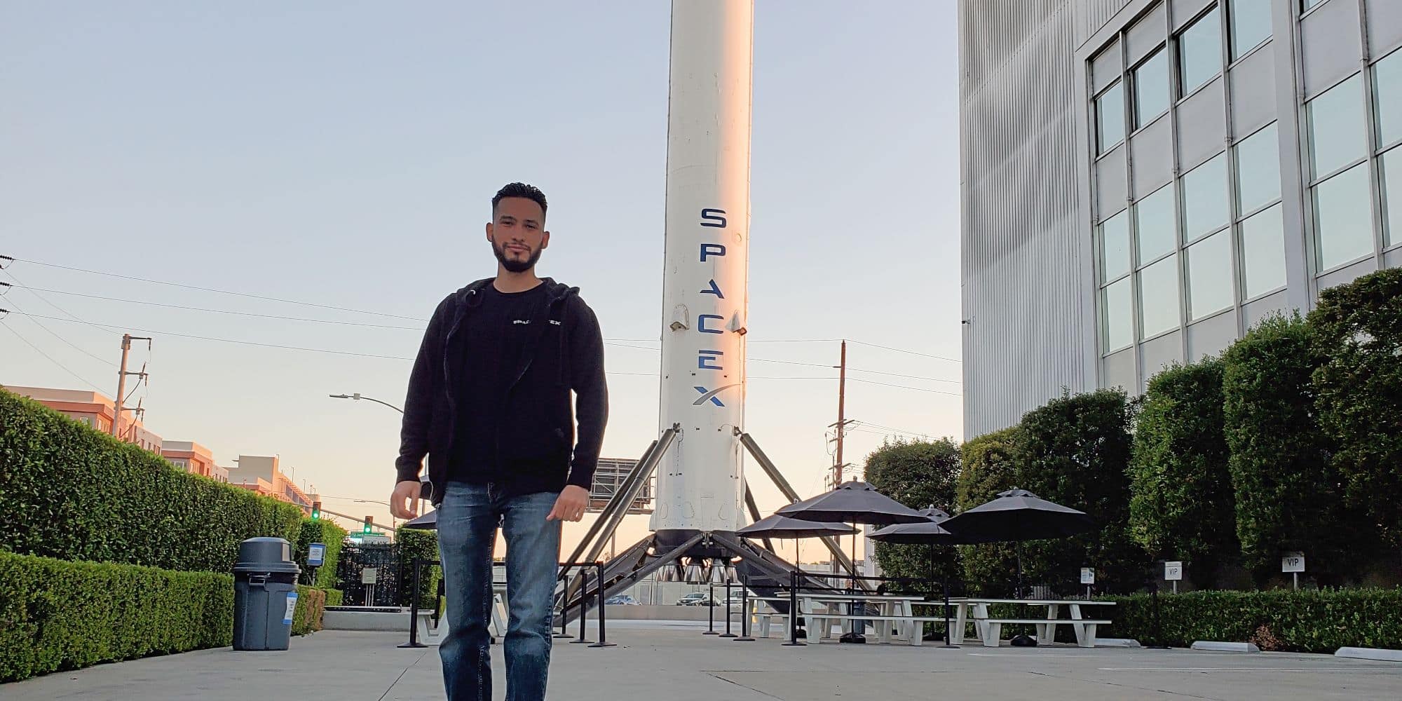 Bachelor of Engineering student Marcos Dominguez stands in front of a SpaceX booster.