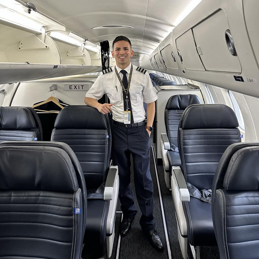 CommuteAir pilot Juan Pena, here inside the cabin of an ERJ145, got an early start to his aviation career at the Gaetz Institute. (Photo: Juan Pena)