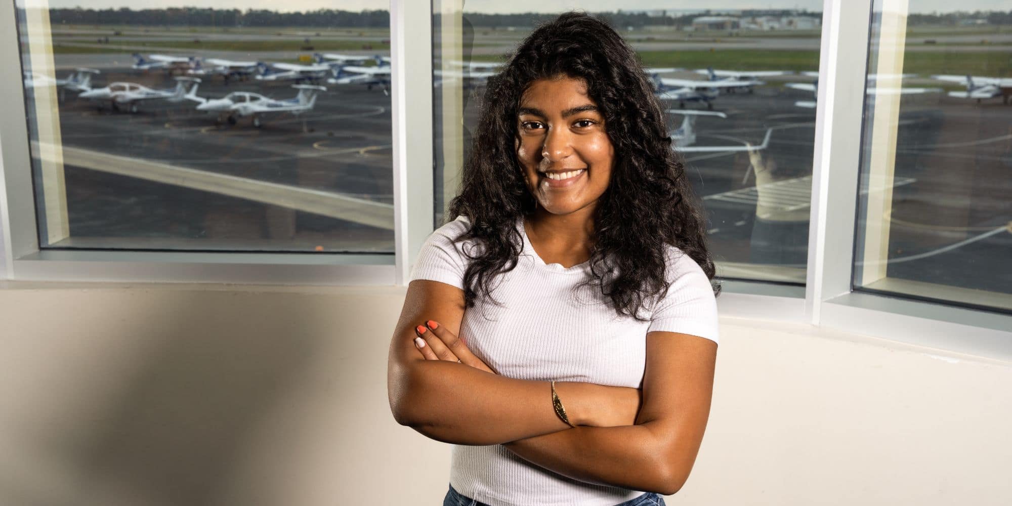 Boeing Scholar and Aeronautical Science major Kaylee Lall ('26) in Embry-Riddle's Flight building overlooking the ramp. (Photo: Embry-Riddle / Bill Fredette-Huffman)