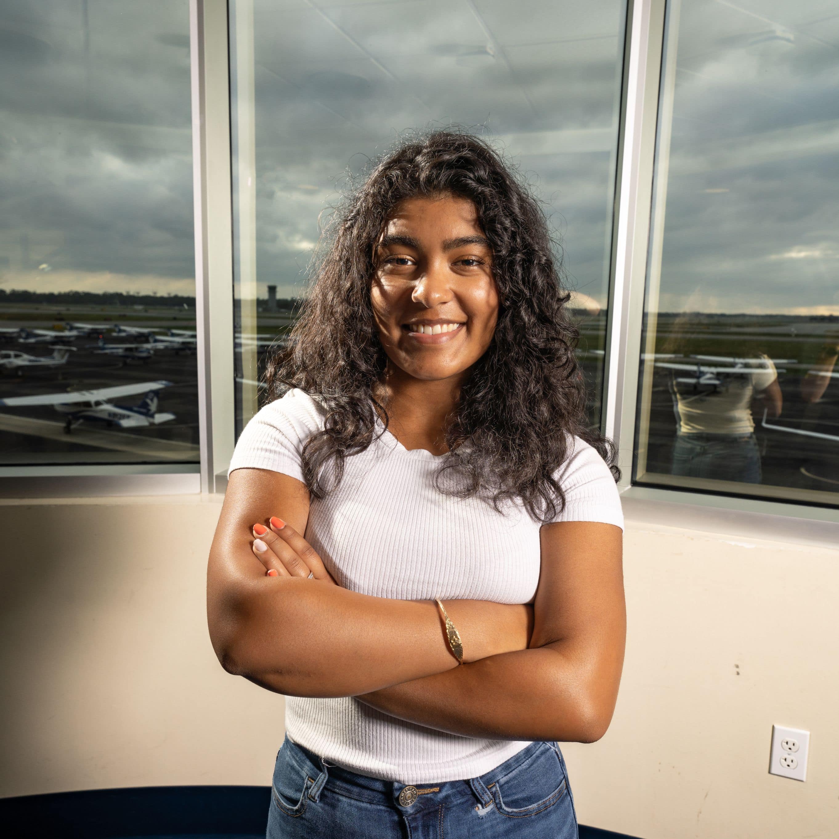 Boeing Scholar and Aeronautical Science major Kaylee Lall ('26) in Embry-Riddle's Flight building overlooking the ramp. (Photo: Embry-Riddle / Bill Fredette-Huffman)