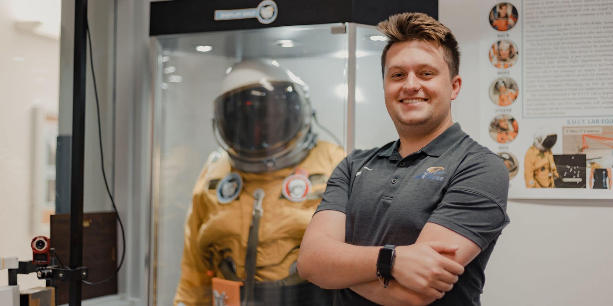 Niko Blanks, seen here next to a space suit, is pursuing a B.S. in Spaceflight Operations with minors in Human Factors and Systems Engineering. (Photo: Josh Asiaten)