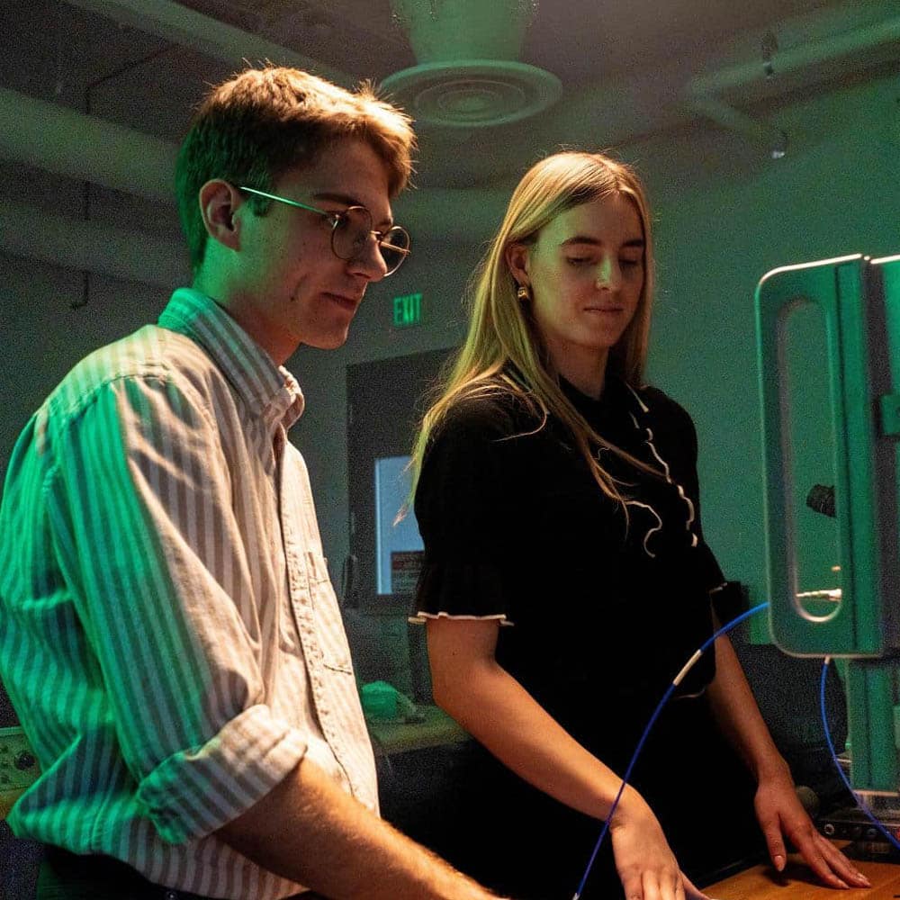 Two people working on a machine.