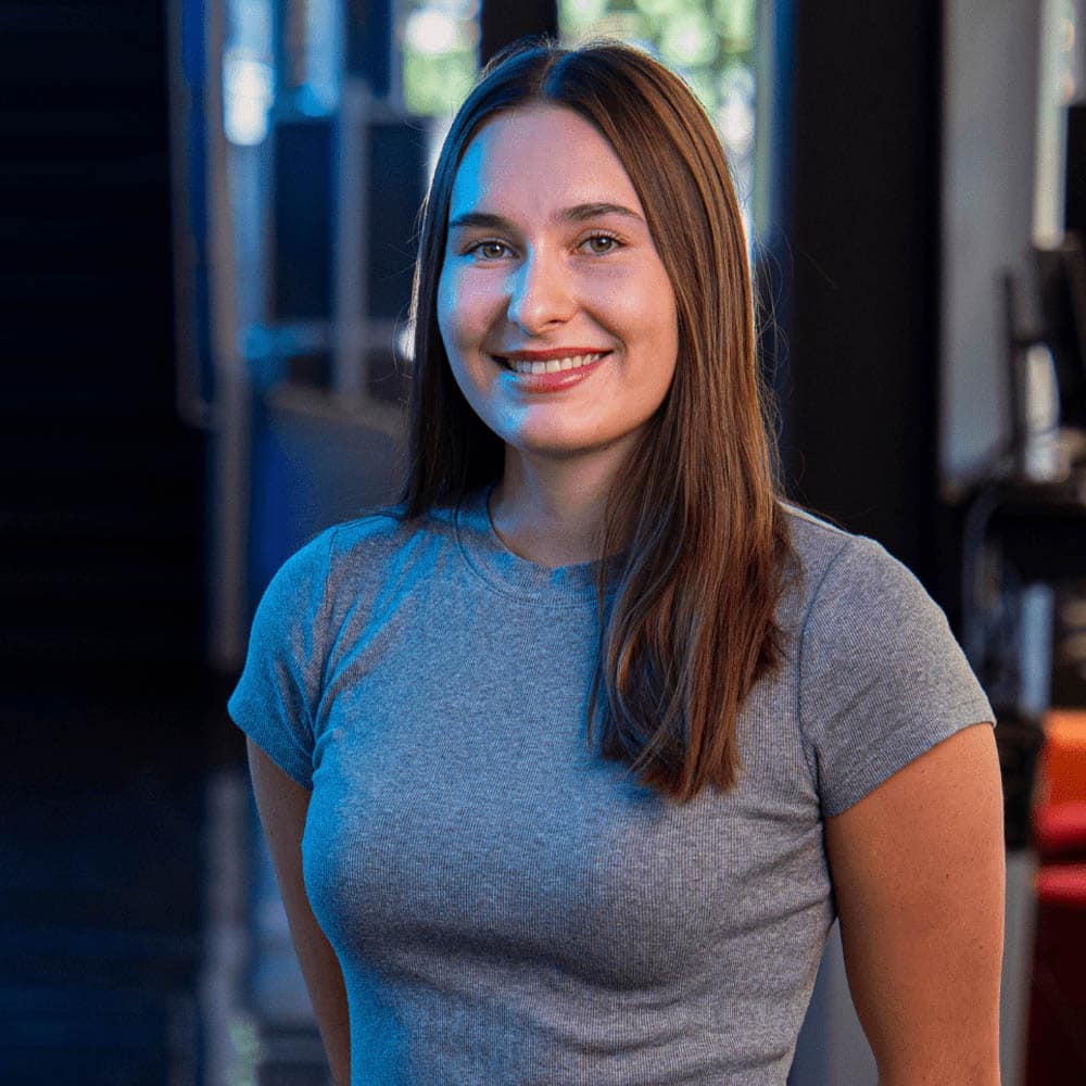 A person with long brown hair, smiling for the camera.