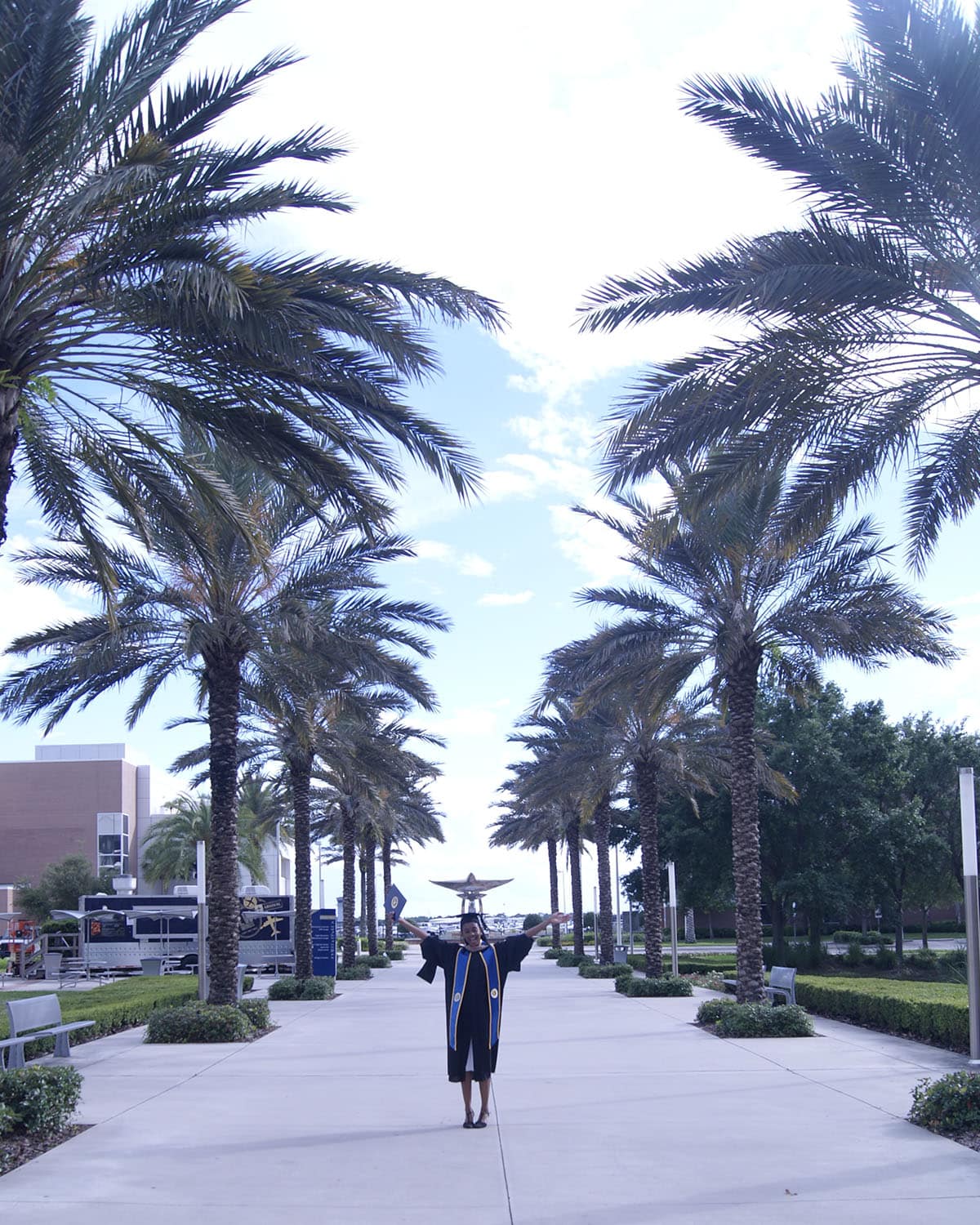 On a palm-tree lined walkway at Embry-Riddle’s Daytona Beach Campus, Zoey Williams celebrates earning her master’s degree. (Photo: Zoey Williams)
